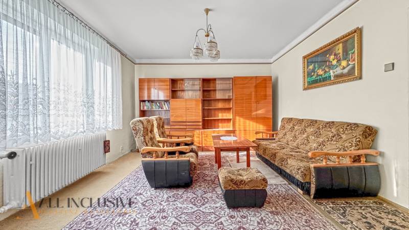 Living room in a family house with carpets, furniture, and armchairs, with a decorative painting.
