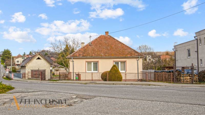 A family house in Prašice on Nemečkovská Street with a fence and a sloped roof.