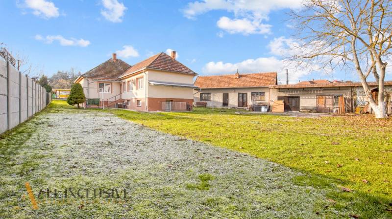 A family house on Nemečkovská Street in Prašice with a large garden and buildings in the background.