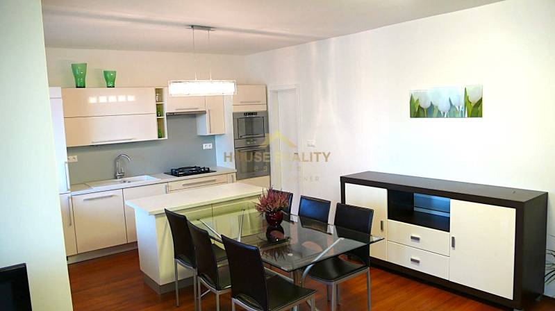Kitchen in a 4-room apartment with a dining table and wood-patterned flooring.