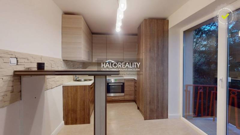 A kitchen unit in a 2-room apartment with a wooden decor floor and balcony doors.
