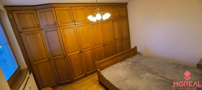 A bedroom in a three-room apartment with a large wardrobe and a bed.