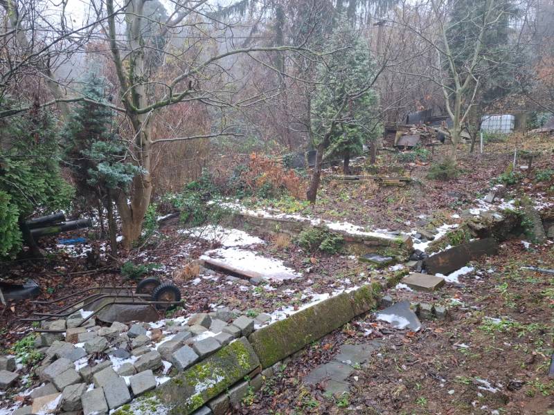 Garden at a family house on Búdková in Bratislava - Staré Mesto, with a broken fence and trees.