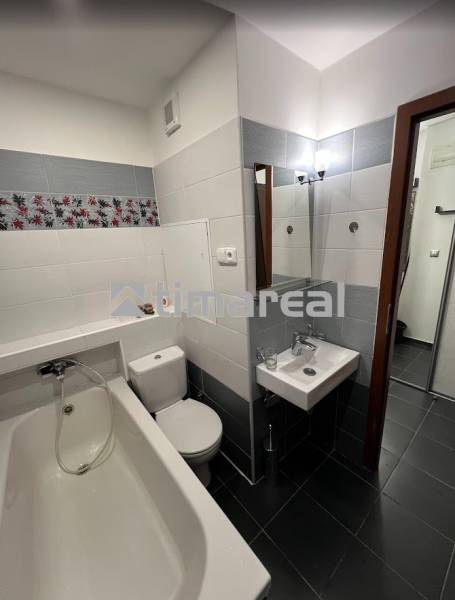 Bathroom in a studio apartment with a bathtub, sink, and toilet.