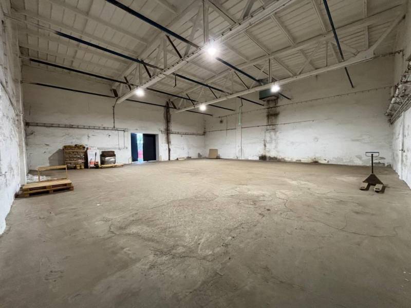 Spacious offices with high ceilings and a pallet jack on a concrete floor.