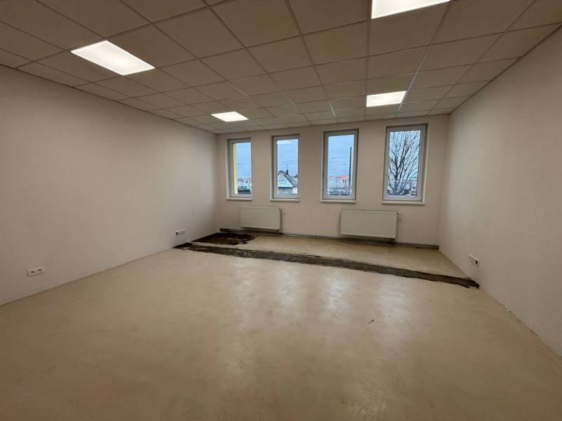 Offices with white walls, floors, and windows, waiting to be completed.