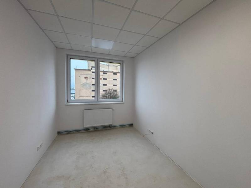 White office with a radiator and a view through the window.