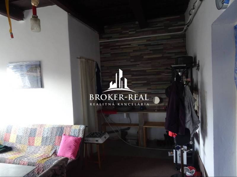 Interior of a family house with a sofa and a coat rack, panelled wall in the background.