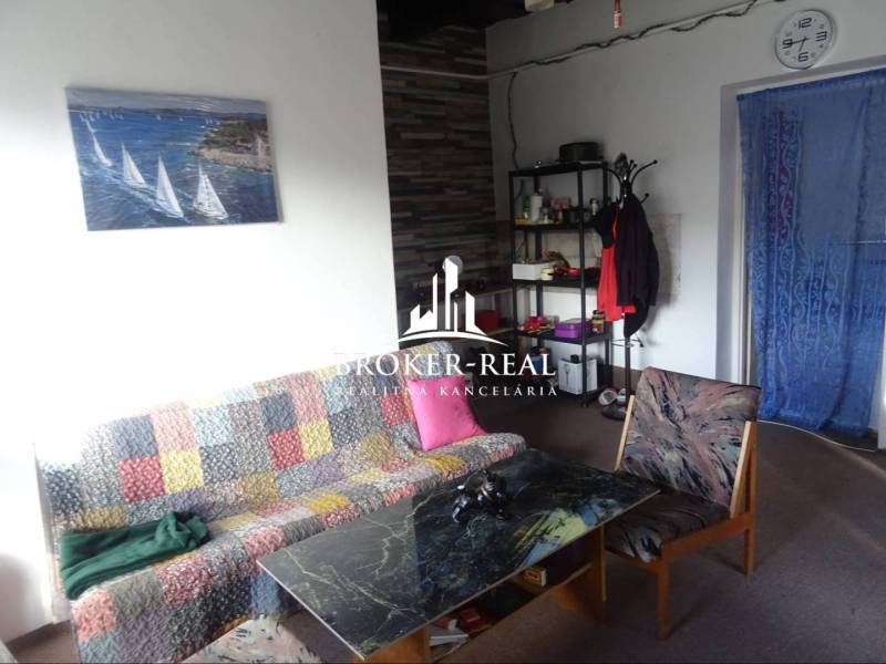 Living room in a family house with a colorful sofa, coffee table, and wall painting.