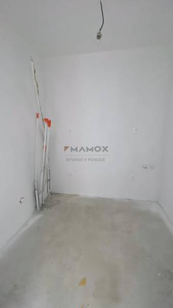 An empty room in a family house with a concrete floor and prepared wiring.