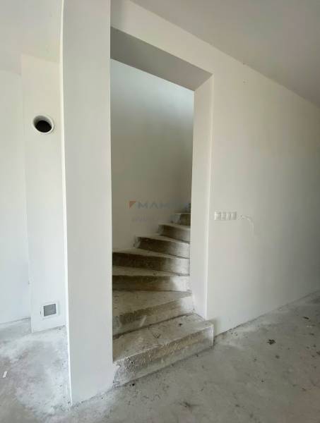 Concrete staircase and neutral wall in a family house, waiting for completion.