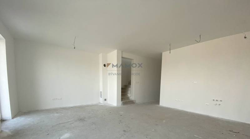 Empty room in a family house with white walls and a concrete floor.