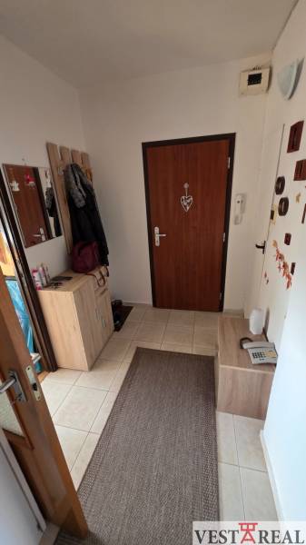 A hallway in a 3-room apartment with light furniture and brown accessories.