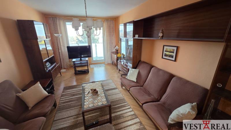 Living room in a 3-room apartment with sofas, cabinets, and wood-patterned flooring.