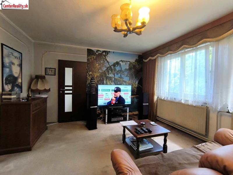 Living room with a television, sofa, table, and large window, Family house.