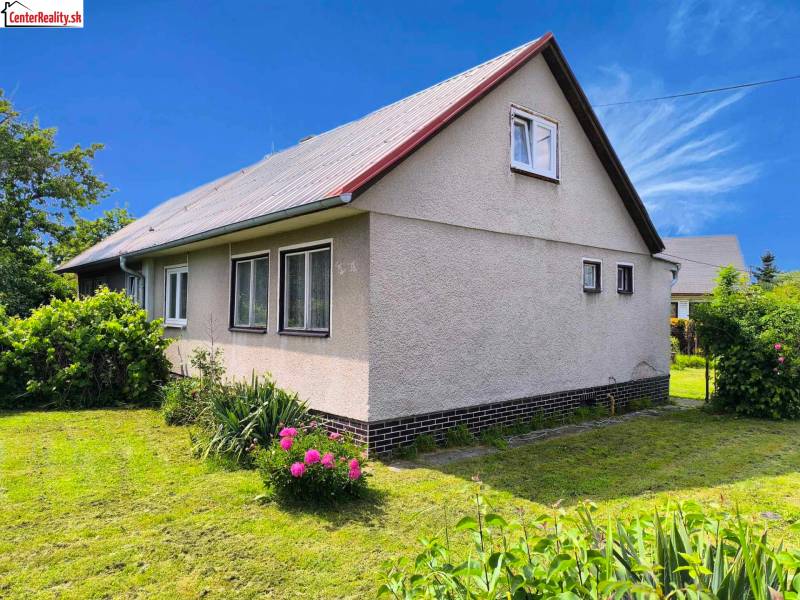 A family house in Nováky with a white facade and a garden full of greenery.