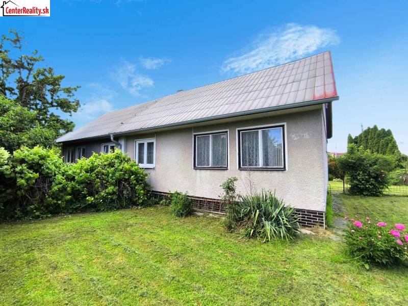 A family house in Nováky with a garden, lawn, and ornamental shrubs.