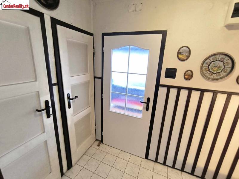 Interior of a family house with white doors, wall decorations, and tiles.