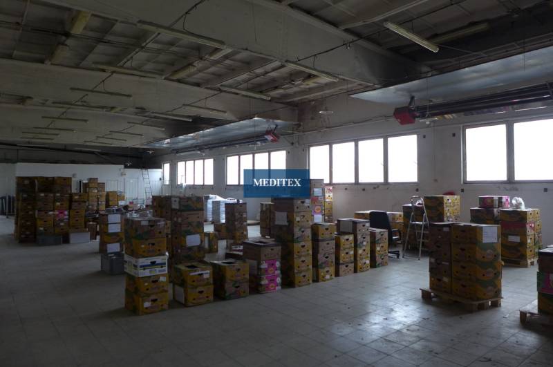 A spacious interior of warehouses and halls with a lot of stacked boxes.