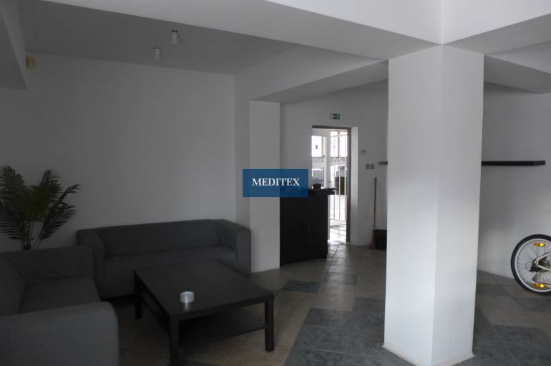 Living space with gray sofas, a coffee table, and tiled flooring in warehouses and halls.