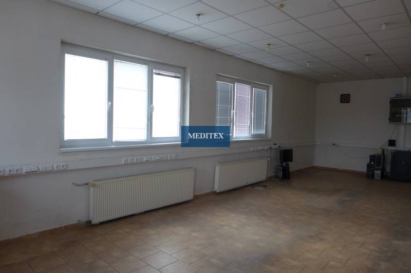 An empty room with wall radiators and tiles in warehouses and halls.