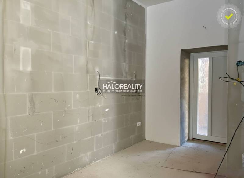 A bright room with unfinished walls in a family house with an entrance door.