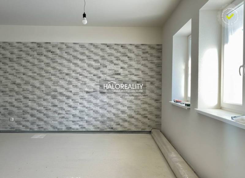 Interior of a family house with a textured wall and an uninstalled wooden decor floor.