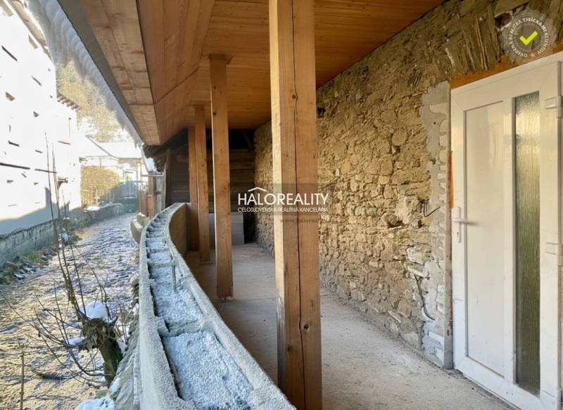 A shelter of a family house in Hronec with a stone wall and a wooden ceiling.
