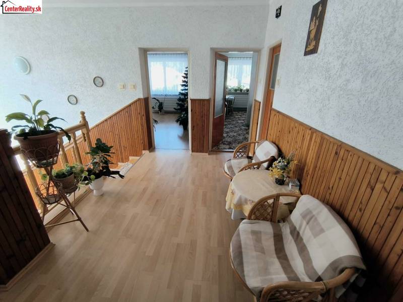 Interior of a family house with a staircase, wooden decor flooring, and a spacious hallway.