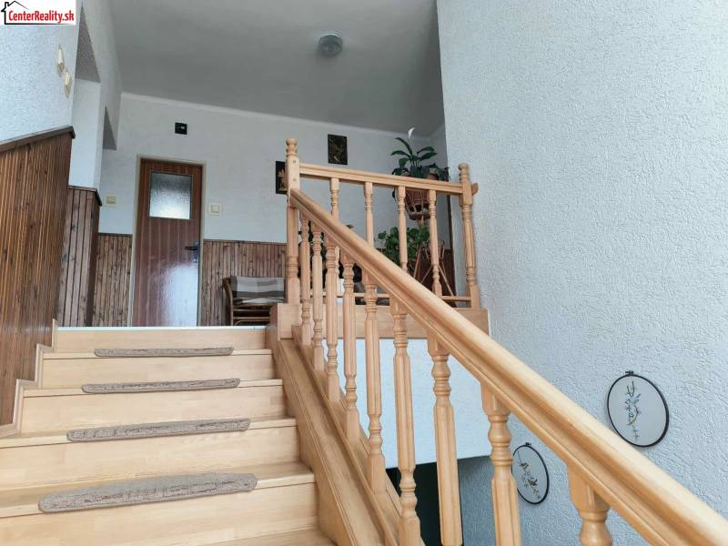A family house with a wooden staircase, wall cladding, and decoration.