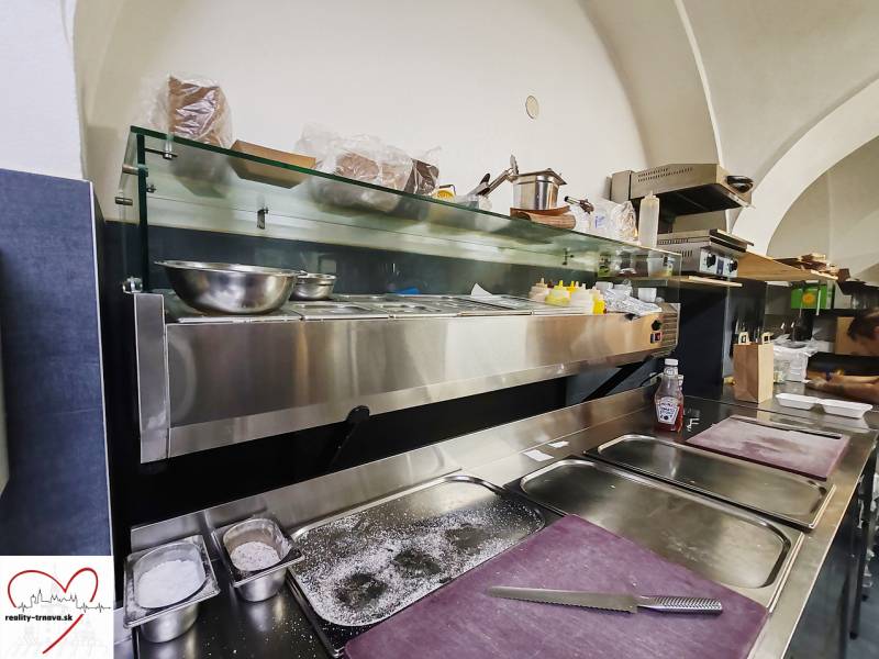 Gastro premises with stainless steel equipment and a preparation area in the room.
