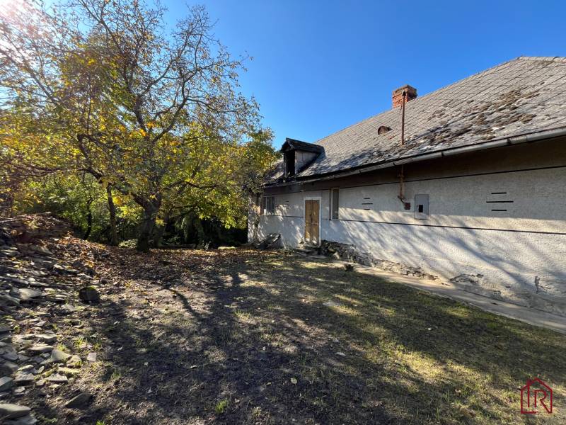 A yard with a house in Rákoš, surrounded by greenery. Land - residential.