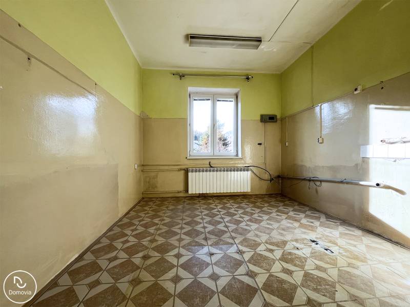 A room in a 5 or more bedroom apartment with a tiled floor and a window.