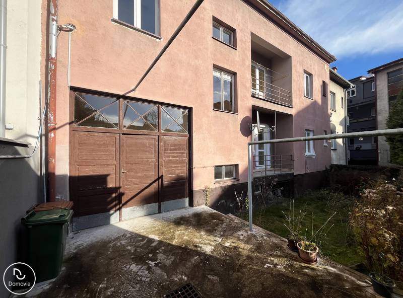 The exterior of the apartment building on Medveckého Street in Ružomberok with a garage and a yard.