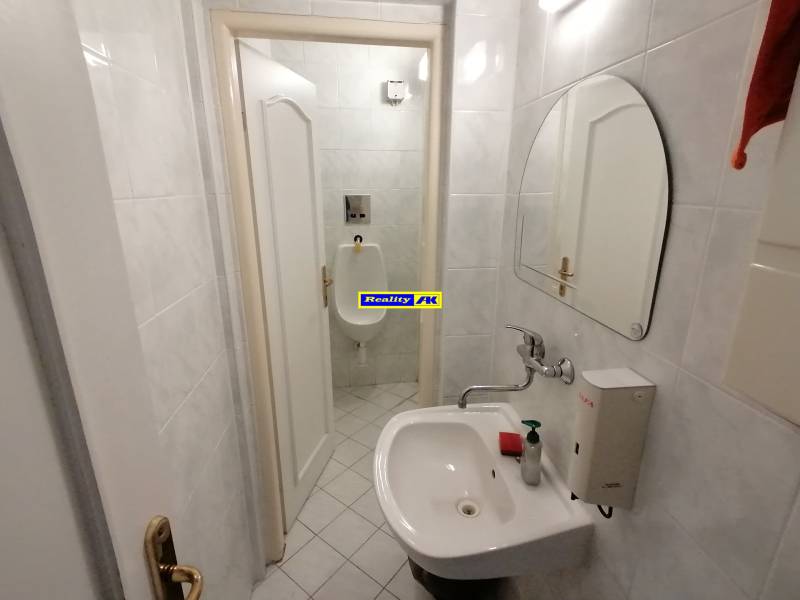 A small bathroom with a sink and a urinal in the offices.