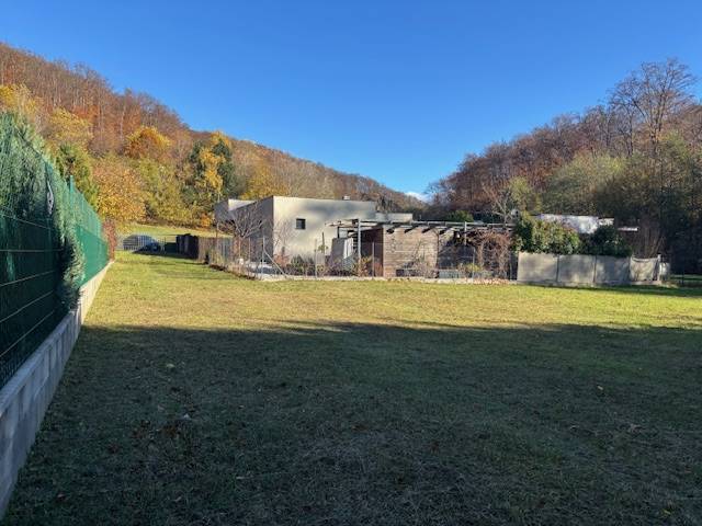 A grassy plot on Karpatská Street in Marianka, surrounded by modern architecture and nature.