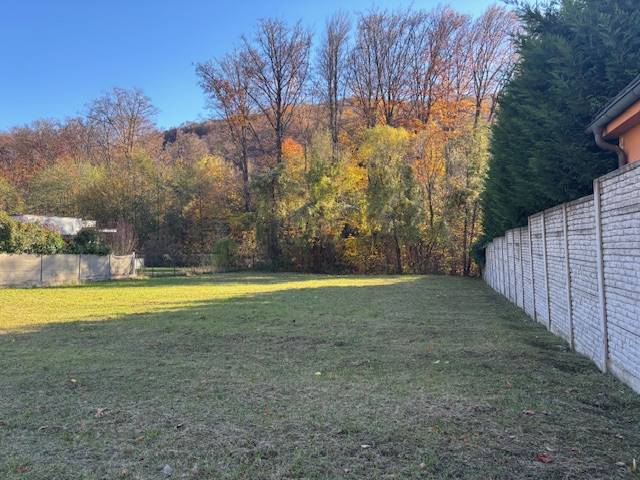 Plots - housing on Karpatská Street, Marianka with a grassy area and trees in the background.