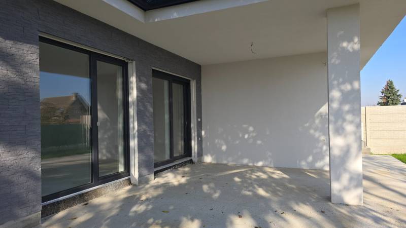 The terrace of a family house in Piešťany with large windows and stone decor.