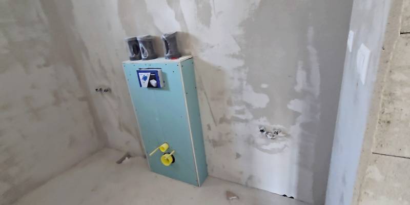 Unfinished bathroom in a family house with prepared wall installation.