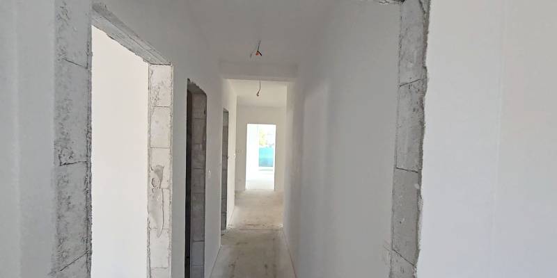 An interior with white walls and a concrete floor ready for finishing in a family house.