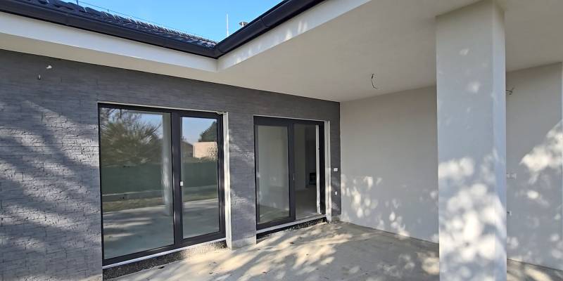 The terrace of a family house in Piešťany with large glass doors and gray walls.