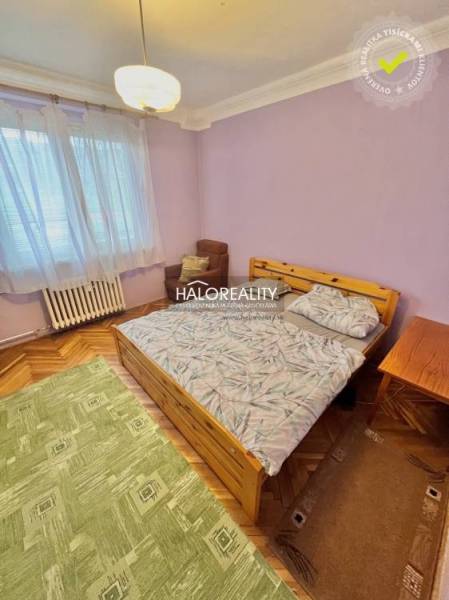 Bedroom in a 4-room apartment with a bed, an armchair, and a wooden decor floor.