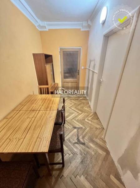 Dining area with a table and chairs on a floor with a wooden decor in a 4-room apartment.