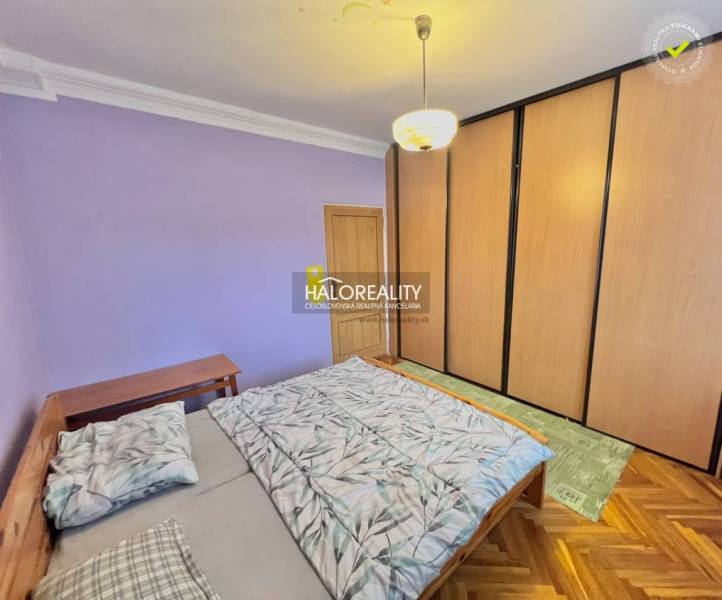 Bedroom in a 4-room apartment with a large built-in wardrobe and a floor with a wooden decor.