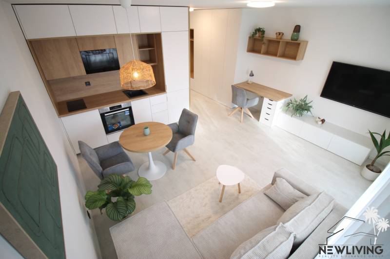 Interior of a 1-room apartment with a kitchen, dining table, and work corner.