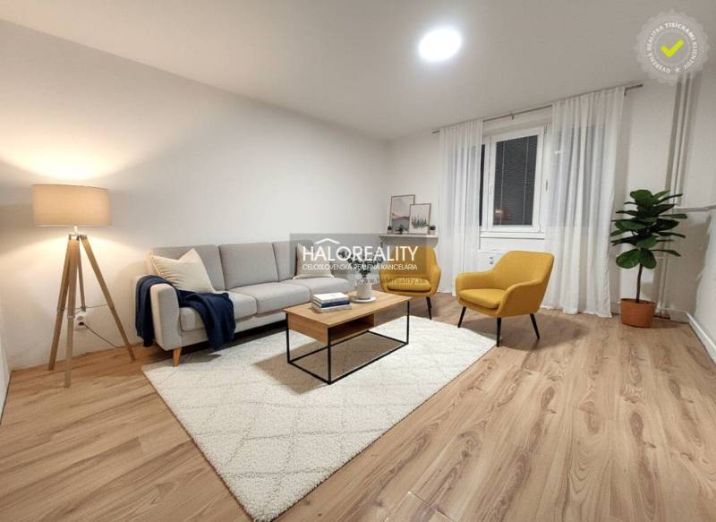 A living room in a two-room apartment with a wooden decor floor and comfortable furnishings.