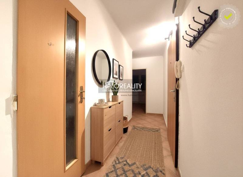 A hallway in a 2-room apartment with wooden decor, a mirror, and a coat rack.
