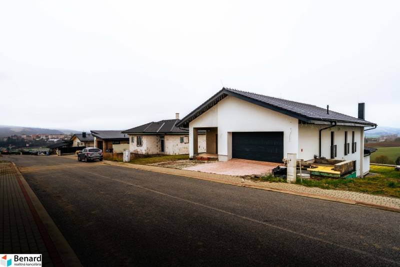 A family house in Stará Ľubovňa with a parked car in front of the garage on a quiet street.