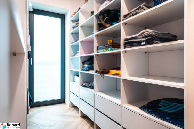 Wardrobe wall and floor with wood decor in the closet of a family house.
