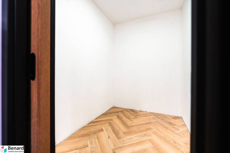Interior with wood-patterned flooring and white walls in a family house.